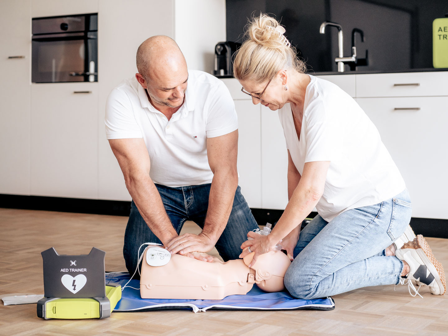 Erwachsene üben an einer Puppe BLS-AED